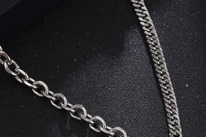 Macro detail of high-shine stainless steel lobster clasp and Cuban link necklace chains