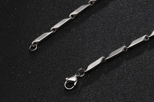 Macro detail of silver stainless steel cylinder link chain with secure lobster clasp