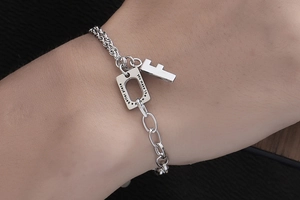 Detail view of silver titanium bracelet with inspirational engraving and letter F charm