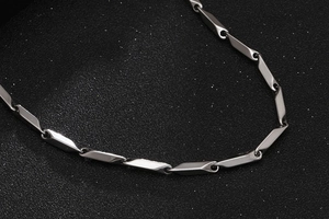 Macro view of masculine stainless steel geometric chain links with industrial silver finish