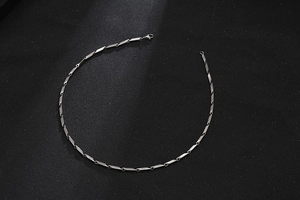 Detail of silver titanium steel necklace featuring geometric cylindrical links and clasp
