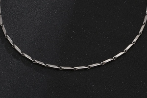 Detail of silver titanium steel necklace with twisted geometric cylindrical links
