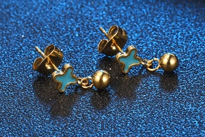 Macro view of gold stud earring with blue star inlay and dangling polished sphere