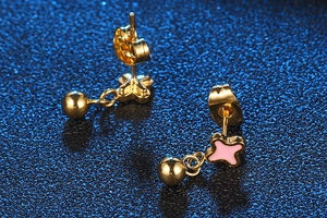 Detailed close-up of gold titanium steel stud earrings with pink star motif and polished bead