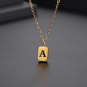 Detaillierte Makroansicht eines goldenen quadratischen Anhängers mit schwarzem Buchstaben A