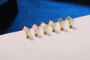 Detail shot of mini star earrings set with pink white and cyan enamel drops in gold