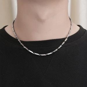 Men's silver stainless steel rectangle link chain necklace worn on a black knit sweater