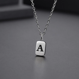 Macro shot of silver letter A pendant on a stainless steel cable chain necklace