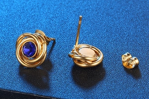 Macro detail of gold round earrings with blue stones, showing S925 butterfly back closure