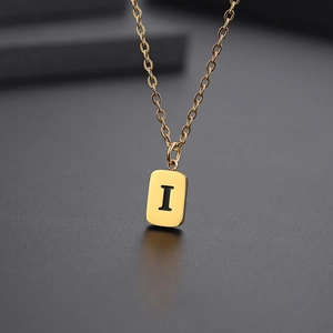 Detailansicht eines goldenen rechteckigen Anhängers mit schwarzem Buchstaben I