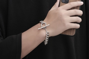 Detailed close-up of a silver men's titanium bracelet with engraved T-bar closure