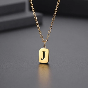 Makroaufnahme von Goldanhänger mit Buchstabe J auf rechteckiger Platte und Kette