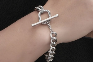 Macro detail of silver king chain bracelet with engraved OT clasp for men