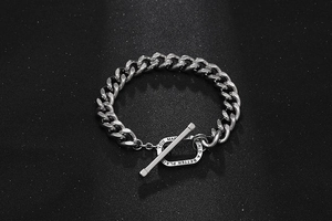 Detail of silver titanium cuban chain bracelet featuring a T-bar clasp with engraving