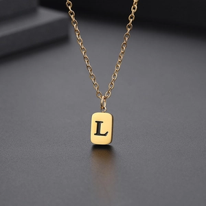 Makroaufnahme der goldenen Halskette mit quadratischem Anhänger und graviertem L-Buchstaben