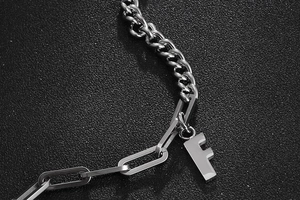 Detailansicht der silberfarbenen Titanstahl-Gliederkette mit einem Anhänger des Buchstaben F