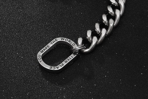 Macro shot of silver titanium steel chain bracelet with motivational engraving detail