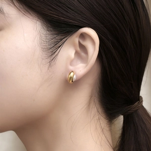 Élégantes boucles d'oreilles dorées avec perles blanches sur un mannequin féminin