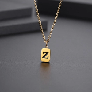 Nahaufnahme der goldenen Halskette mit rechteckigem Anhänger und graviertem Buchstaben Z
