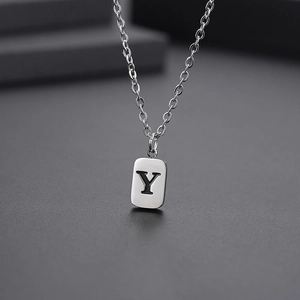 Macro shot of a silver titanium steel rectangle pendant featuring a black engraved letter Y