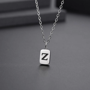 Detail of a rectangular silver pendant engraved with the letter Z on a steel chain