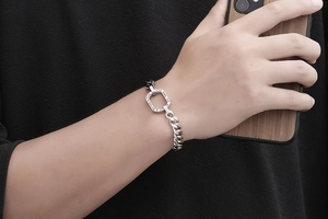 Vue macro d'un bracelet gourmette bicolore en acier titane avec anneau gravé