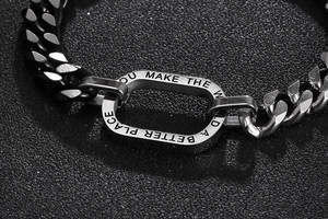 Détail macro du bracelet gourmette bicolore avec citation inspirante gravée dessus
