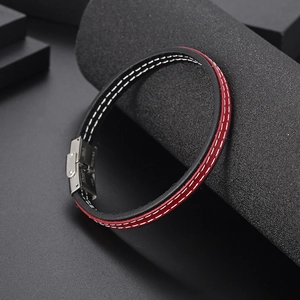 Dettaglio del bracciale in pelle intrecciata rossa e nera con chiusura in acciaio inox