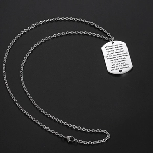 Titanium steel dog tag necklace with motivational engraving on a black background