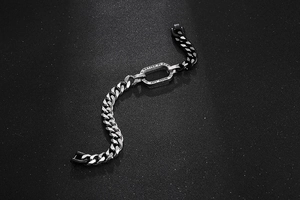Détail d'un bracelet à maillons bicolore avec plaque métallique gravée en argent et noir