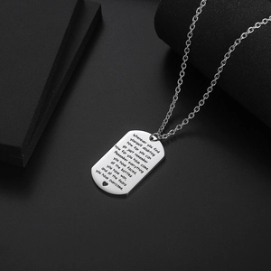 Polished stainless steel dog tag necklace with engraved inspirational text on dark background