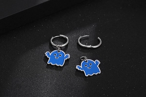 Dettaglio di orecchini in acciaio con fantasma in smalto blu e cerchi in argento