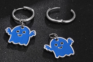 Dettaglio macro di orecchini fantasma in smalto blu con cerchi in acciaio su fondo nero