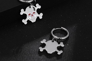 Detail of gothic skull and crossbones earrings with red enamel eye accents and steel finish