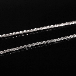 Macro-opname van een zilveren titanium stalen ketting met sprankelende textuur op zwart