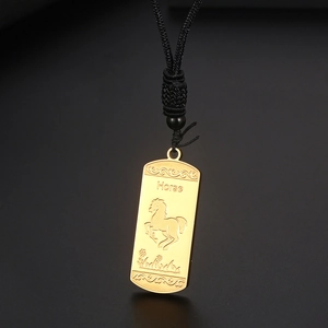 Détail d'un pendentif cheval zodiaque doré avec motifs de vagues sur cordon noir tressé