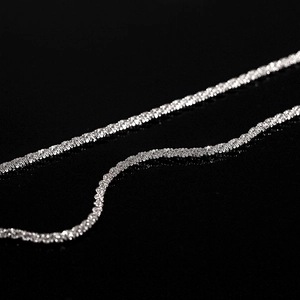 Macro-opname van een glinsterende titanium stalen ketting op een reflecterende zwarte basis
