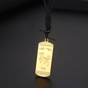Détail du pendentif doré rectangle signe chinois chien avec motifs floraux et cordon noir