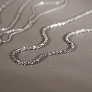 Macro-detail van glinsterende titanium stalen halsketting met sprankelende textuur