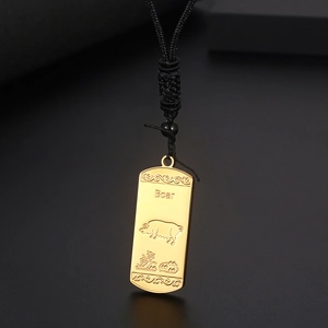 Gros plan du pendentif doré signe du zodiaque cochon avec cordon noir et gravure fine