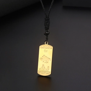 Vue détaillée du pendentif zodiaque bœuf doré avec gravure précise et cordon tressé