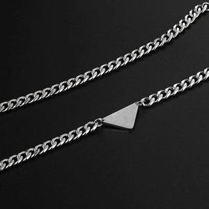Collar de eslabones cubanos plateados con colgante triangular sobre fondo negro
