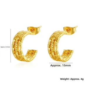 Detailed view of C-shaped gold hoop earrings with textured diamond-cut surface finish