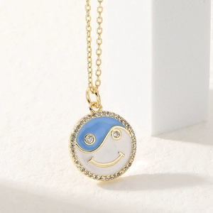 Golden yin yang smiley face necklace with blue and white enamel and zircon accents