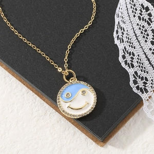 Chic gold necklace with a micro-pave smile yin yang pendant in blue and white enamel