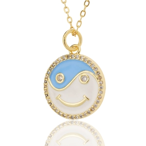 Gold necklace featuring a yin-yang smiley face pendant with blue enamel and pavé zircons
