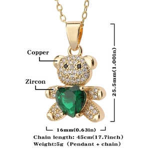 Close-up of gold bear pendant with white zircon and large green heart stone details