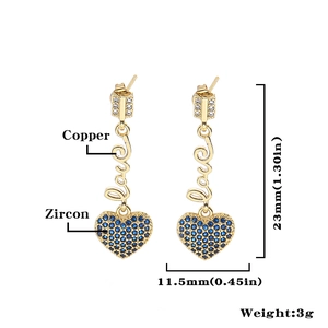 Detailansicht goldener Ohrhänger mit Love-Schriftzug und blauem Zirkonia-Herzanhänger