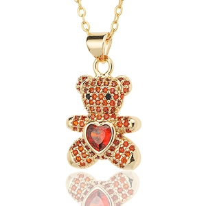 Detail of bear pendant with orange crystals and heart-shaped red gemstone