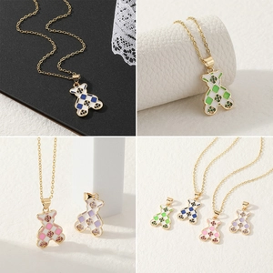 Detail showing four colors of checkered bear pendants with gold plating and crystals